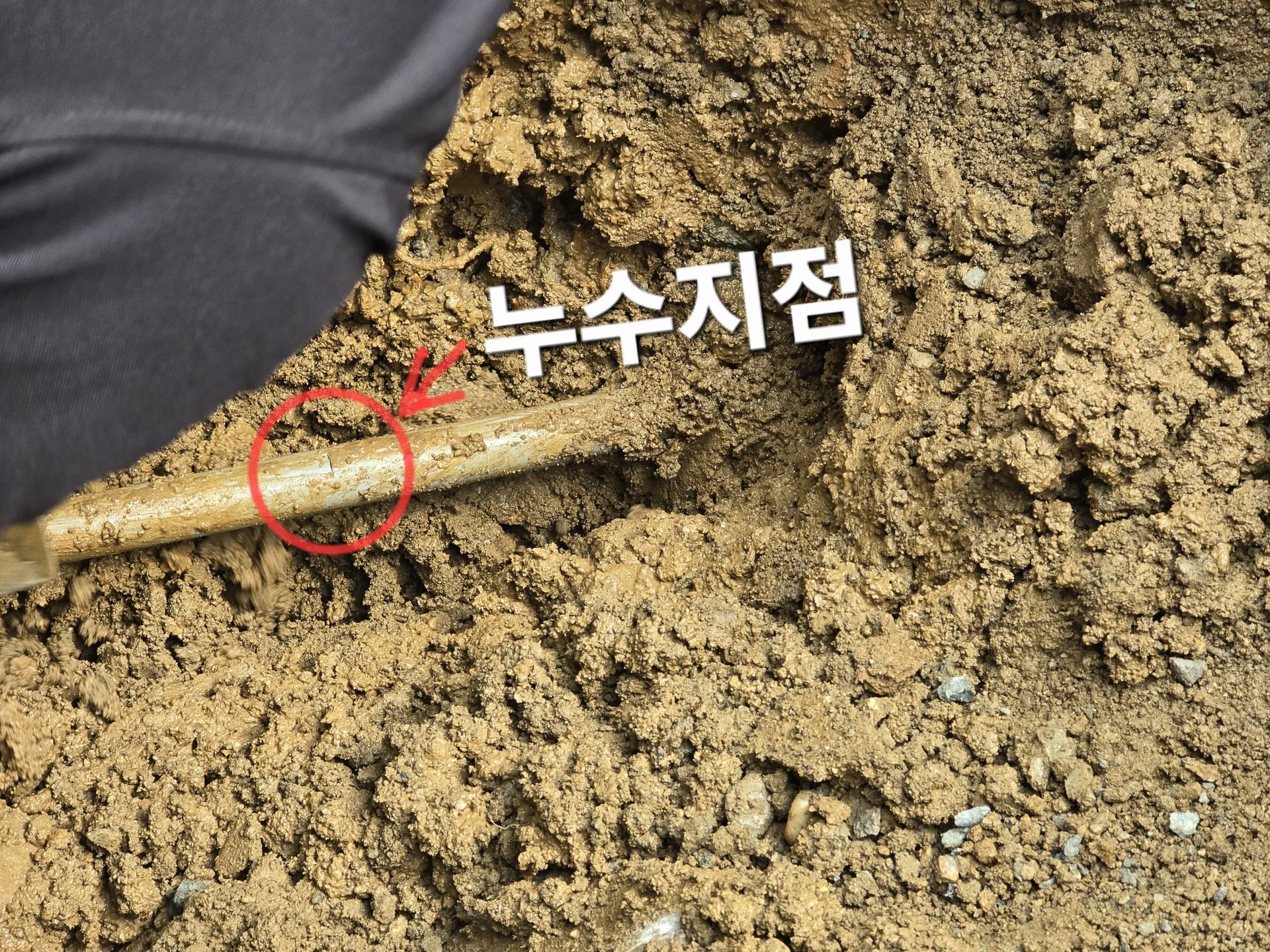 흙 속 배관의 누수 지점을 붉은 원으로 표시해 확정한 누수검사 현장